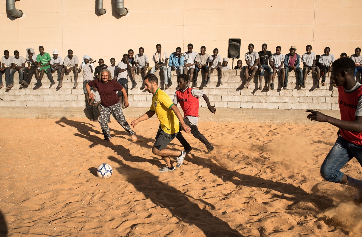 Migrants play football with Libyan guards at the Tariq Al-Matar detention centre on the outskirts of the Libyan capital, Tripoli, on December 18, 2016