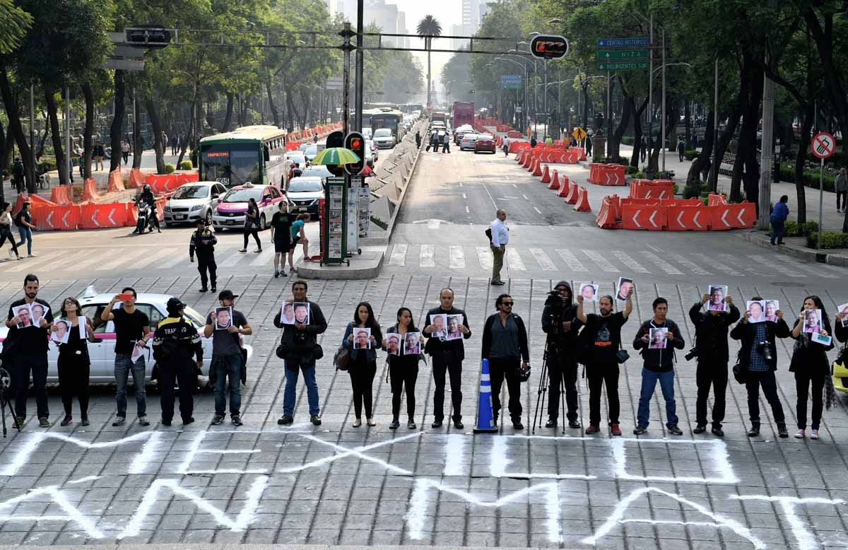 Journalists hold pictures of journalists recently murdered in different Mexican states during a protest by journalistsat at the Independence Angel square in Mexico City on May 16, 2017.