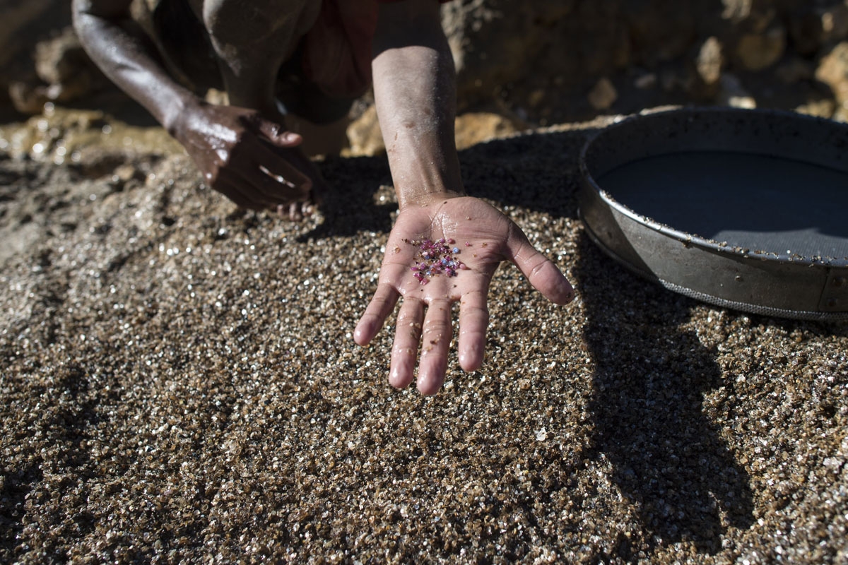 This photo taken on November 25, 2016 shows a miner showing pieces of ruby and jade at a ruby mine in Mogok, north of Mandalay.