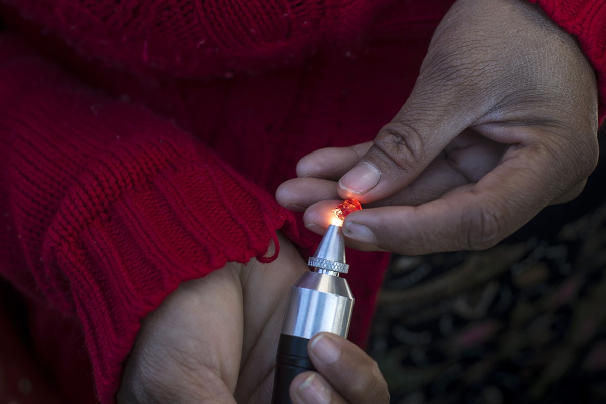 This photo taken on November 25, 2016 shows a buyer checking a ruby in the gems market in Mogok, north of Mandalay.