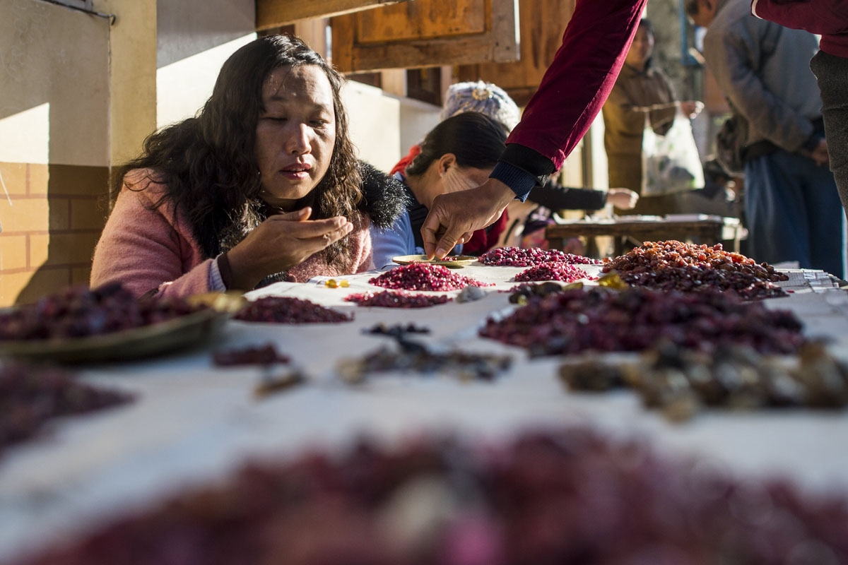 This photo taken on November 25, 2016 shows a buyer looking at rubies in the gems market in Mogok, north of Mandalay.