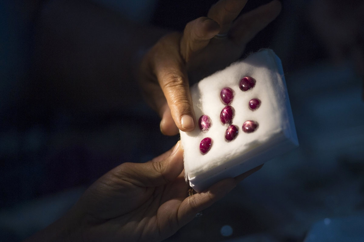 This photo taken on November 22, 2016 shows a buyer looking at rubies in a jade market in Mandalay.
