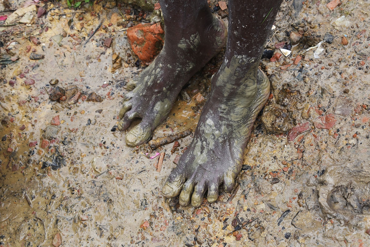 A Rohingya refugee walks in the mud at Thangkhali refugee camp in Bangladesh's Cox's Bazar district on September 17, 2017.