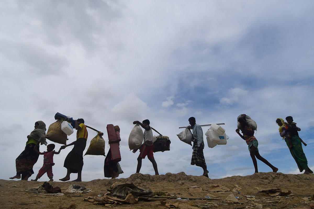 Rohingya refugees walk near the no man's land area between Bangladesh and Myanmar in the Palongkhali area next to Ukhia on October 19, 2017.