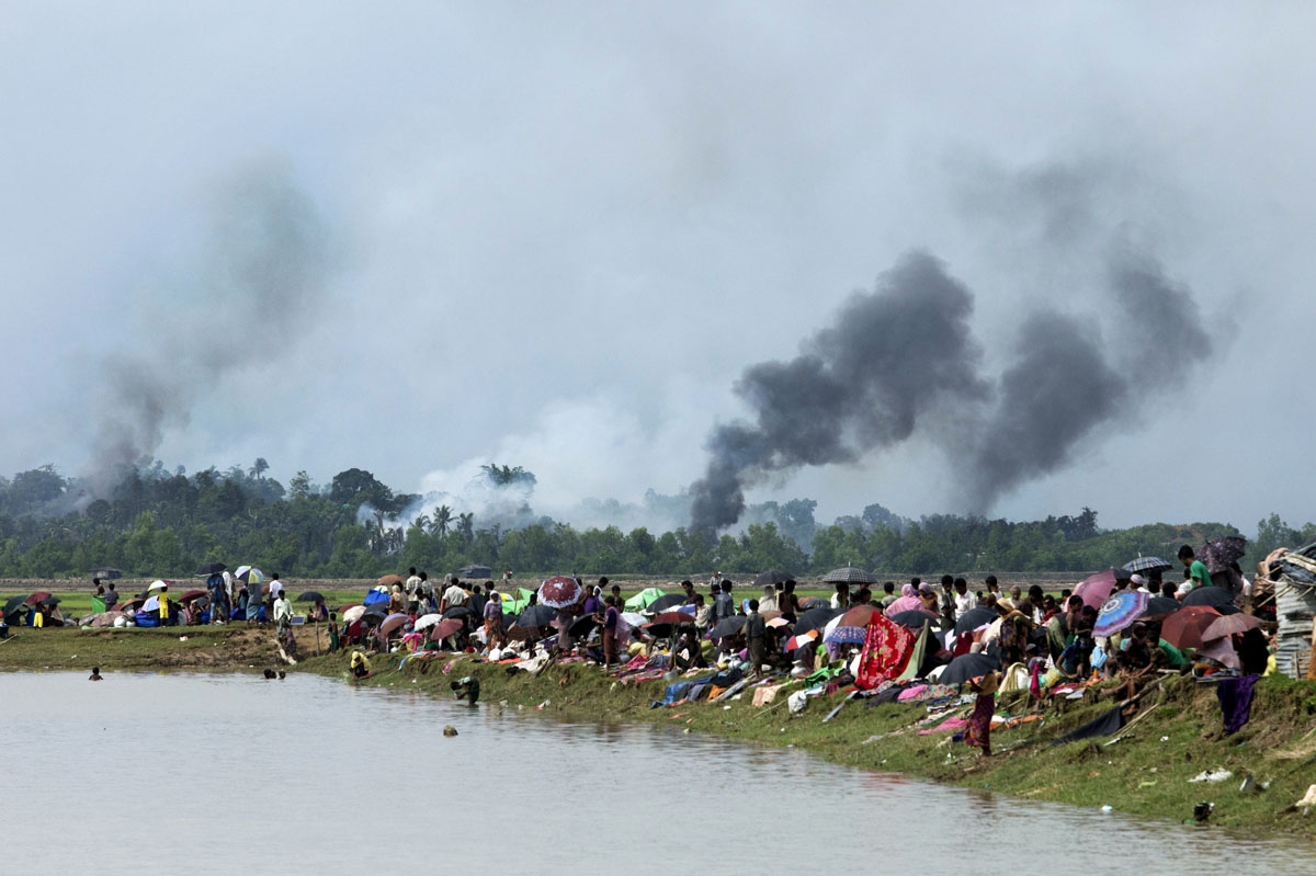 Smoke billows above what is believed to be a burning village in Myanmar's Rakhine state as members of the Rohingya Muslim minority take shelter in a no-man's land between Bangladesh and Myanmar in Ukhia on September 4, 2017.