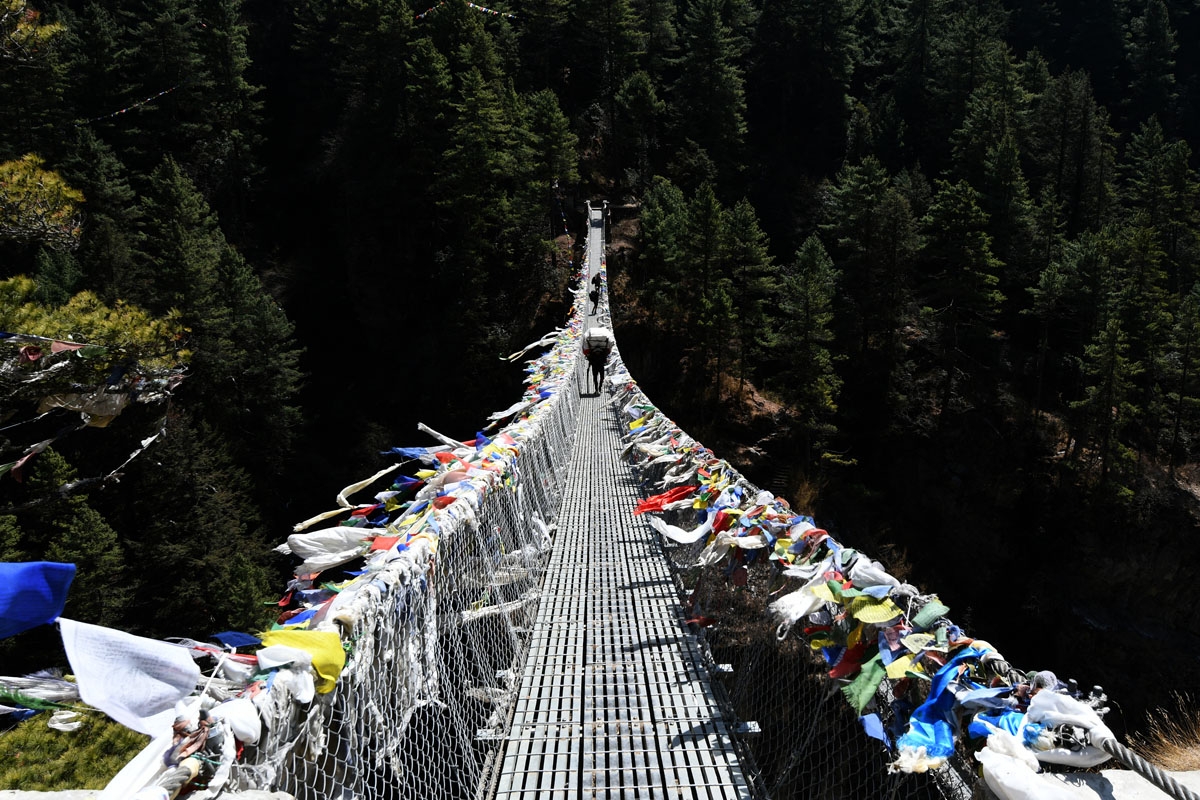 Nepali porters cross a suspension bridge to Namche Bazar, April, 2018.