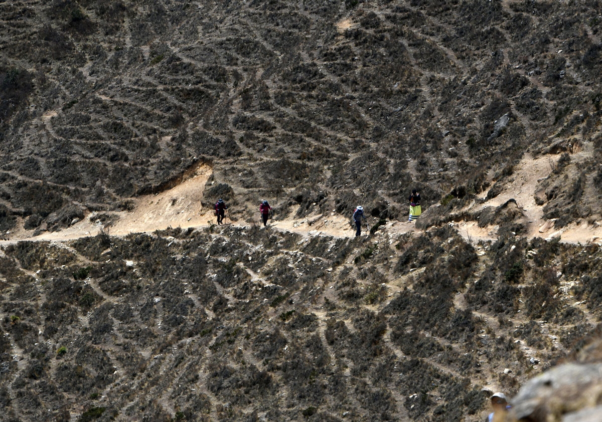Trekkers walk along a path at the Everest region, some 140 km northeast of Kathmandu, on April 17, 2018.