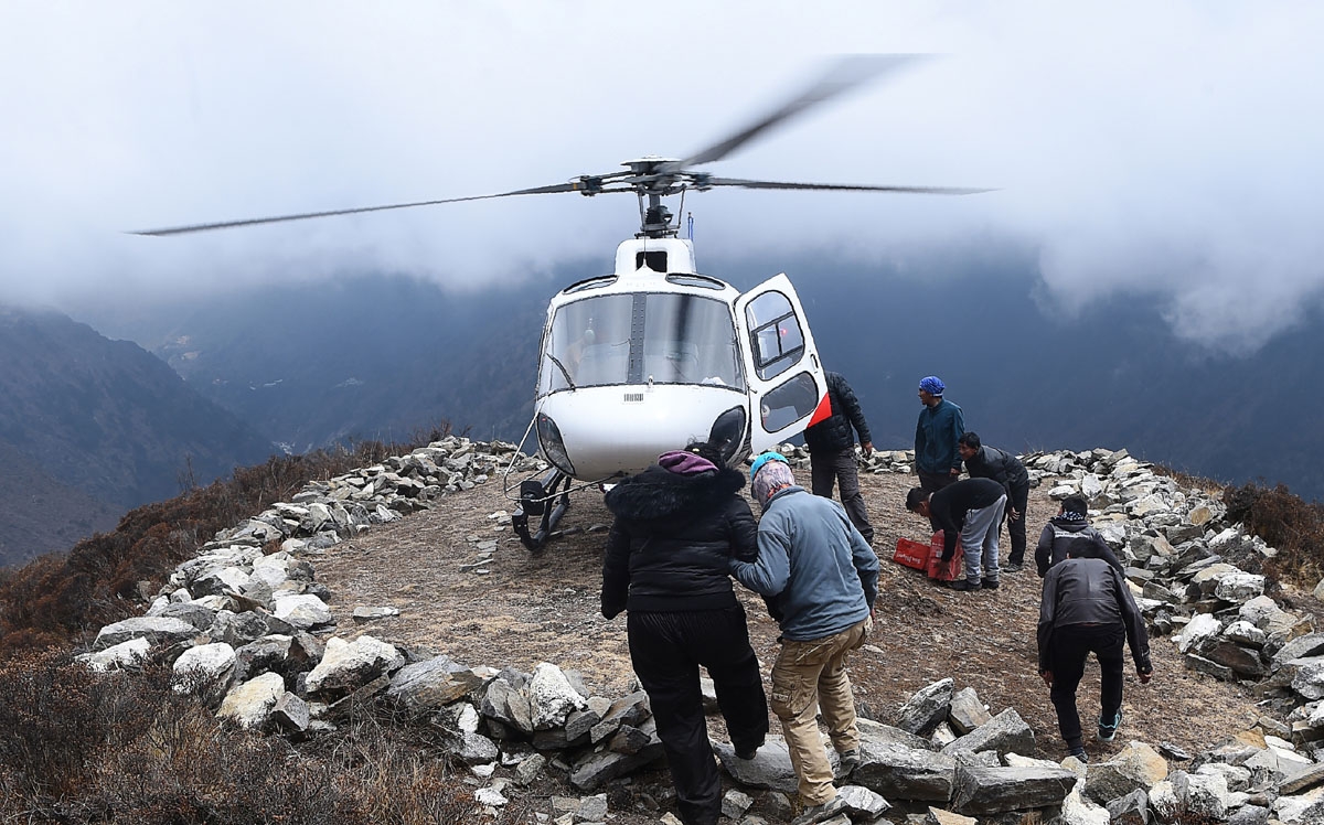 An unidentified injured person is helped to board a helicopter at the Mong La village near Namche Bazar, April 17, 2018.