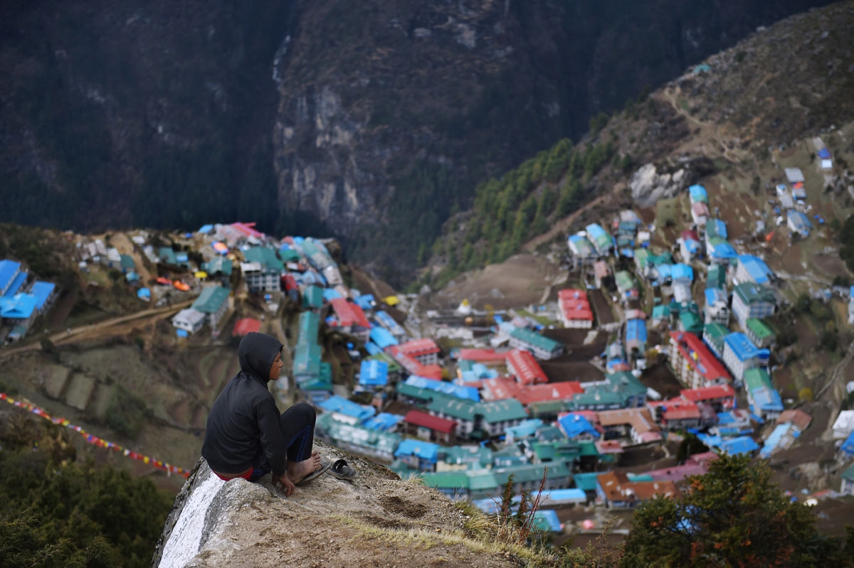 Nepali porter Milan Rai, 14, rests as he makes his way up a rocky path high above the north-eastern town of Namche Bazar, April 18, 2015.