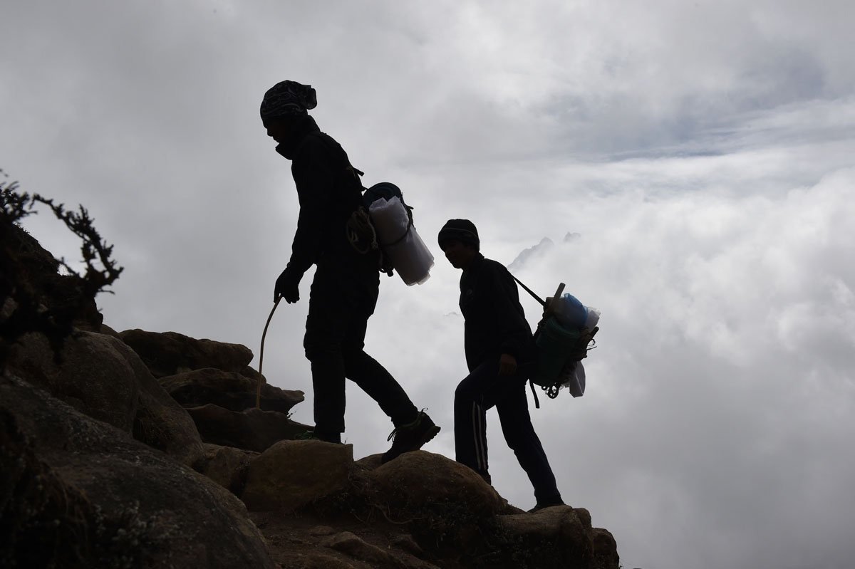 Nepalese porters walk up a path high above the north-eastern town of Namche Bazar, April 18, 2015.