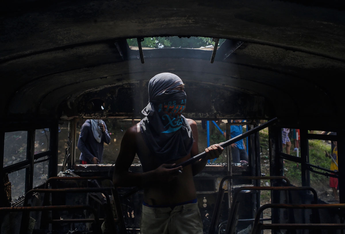 A demonstrator stands inside a bus set alight during a day-long national strike held to mark two months of violent chaos under President Daniel Ortega, in Tipitapa, about 25 km from Managua on June 14, 2018