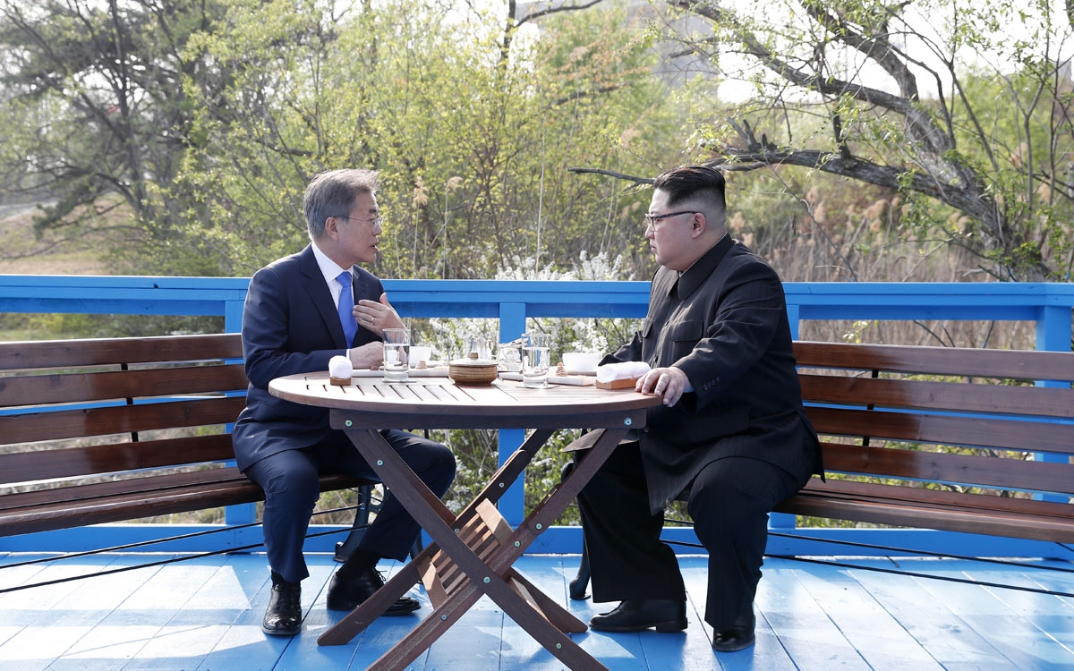 North Korea's leader Kim Jong Un (R) talks with South Korea's President Moon Jae-in (L) at a bench on a bridge next to the military demarcation line at the truce village of Panmunjom on April 27, 2018. The leaders of the two Koreas held a landmark summit