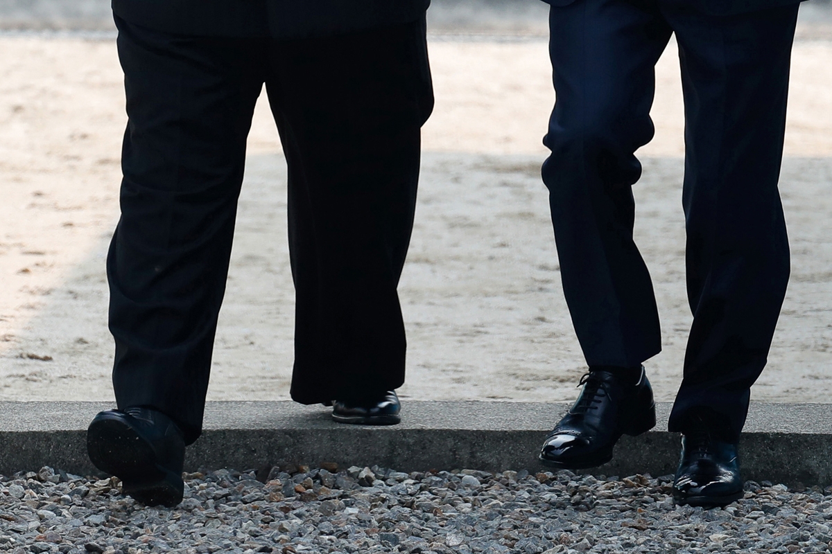North Korea's leader Kim Jong Un (L) steps into the South Korean side over the Military Demarcation Line that divides the two Koreas with South Korea's President Moon Jae-in (R) ahead of their summit at Panmunjom on April 27, 2018.