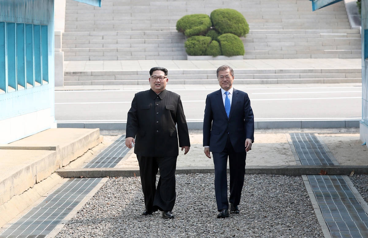 North Korea's leader Kim Jong Un (L) walks with South Korea's President Moon Jae-in (R) to the official summit Peace House building for their meeting on the southern side of the truce village of Panmunjom on April 27, 2018.