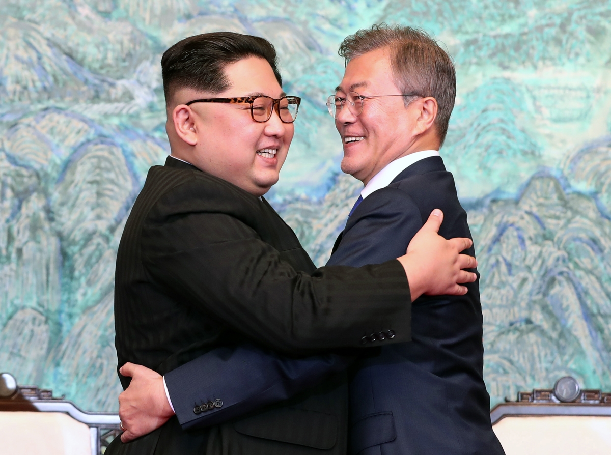 Kim Jong-Un (à gauche) et L) and South Korea's President Moon Jae-in (R) hug during a signing ceremony near the end of their historic summit at the truce village of Panmunjom on April 27, 2018.