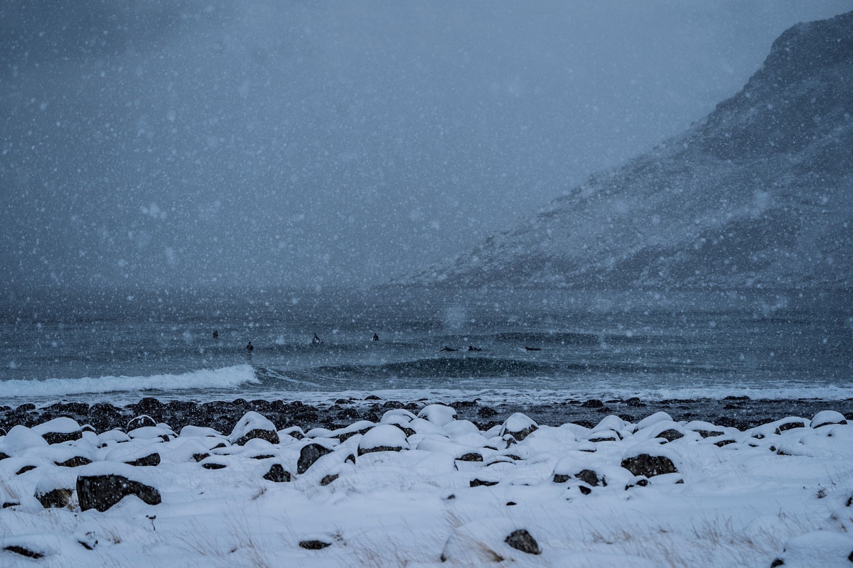Surfers ride waves under snowfall on March 11, 2018, in Unstad, northern Norway, Lofoten islands, within the Arctic Circle as air temperature drops minus 13°C and water temperature above 4°C.