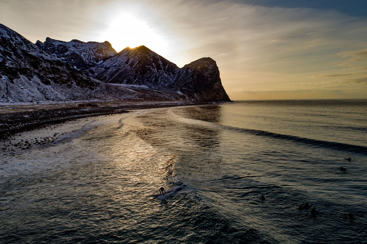 A surfer rides a wave on March 10, 2018 in Unstad, northern Norway, Lofoten islands, within the Arctic Circle as air temperature drops minus 13°C and water temperature above 4°C. / AFP PHOTO / OLIVIER MORIN