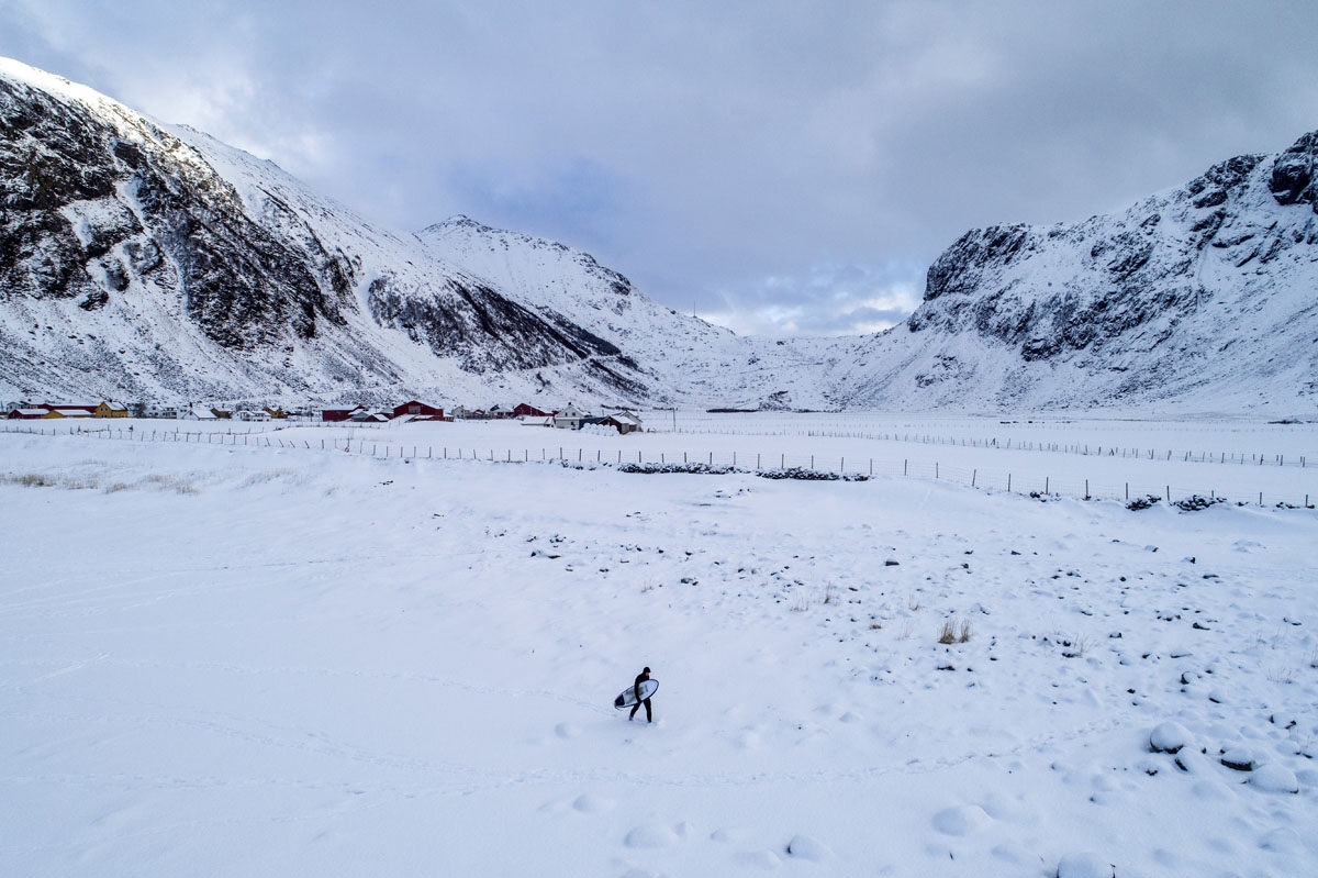 A surfer carries his surfboard as he walks through the snow out of the water on March 11, 2018 in Unstad, northern Norway, Lofoten islands, within the Arctic Circle as air temperature drops minus 13°C and water temperature above 4°C. /