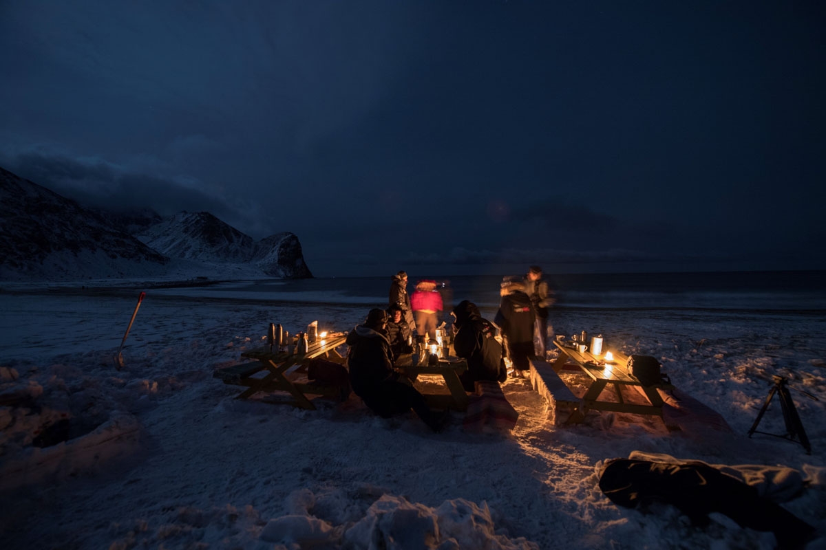 Surfers rest in front of a camp fire after an evening of surfing in Unstad along the northern Atlantic Ocean on March 12, 2017, where the water temperatures is at five degrees centigrade and the air temperature is at minus two degrees centigrade.