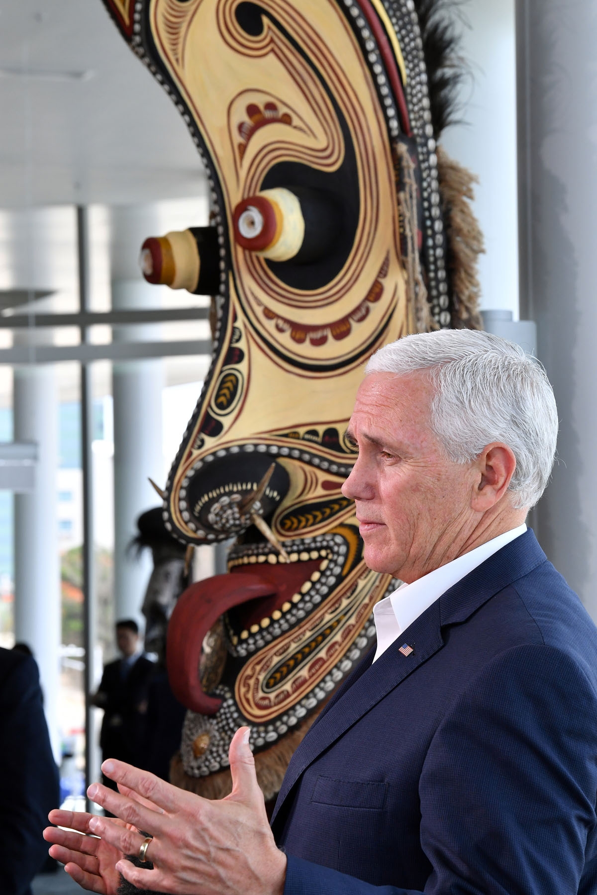 US Vice President Mike Pence speaks to the media while standing next to a traditional mask display, at the end of meetings at the Asia-Pacific Economic Cooperation (APEC) Summit in Port Moresby on November 18, 2018. (