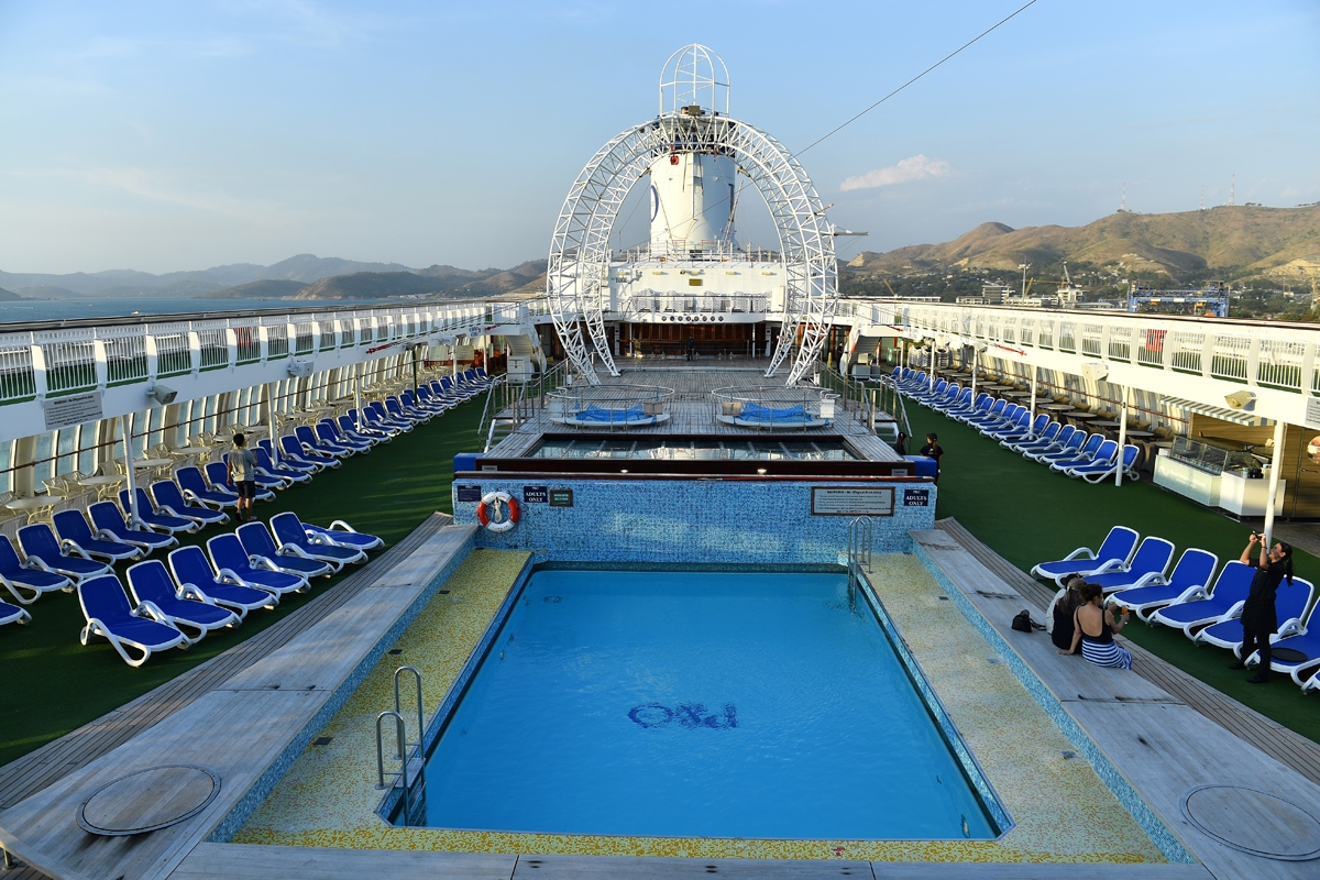 This picture taken on November 13, 2018 shows people on the deck of the cruise ship Pacific Jewels, which will accommodate delegates and journalists at this year's Asia-Pacific Economic Cooperation (APEC) Summit, in Port Moresby.