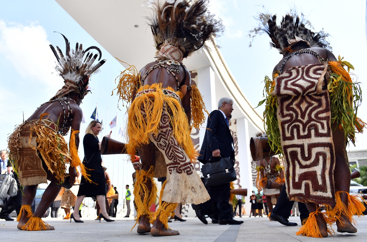 Performers in traditional costumes and headdress welcome delegates and ministers to the international convention centre for the 30th Asia-Pacific Economic Cooperation (APEC) ministerial meeting in Port Moresby on November 15, 2018.