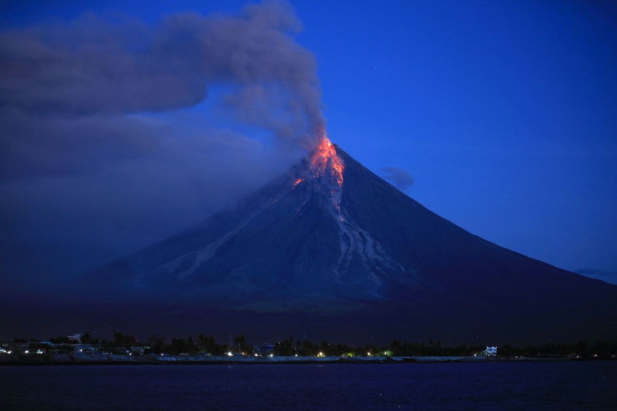 Lava spews from the Mayon volcano as it continues to erupt, seen from Legazpi City in Albay province, south of Manila early on January 23, 2018.