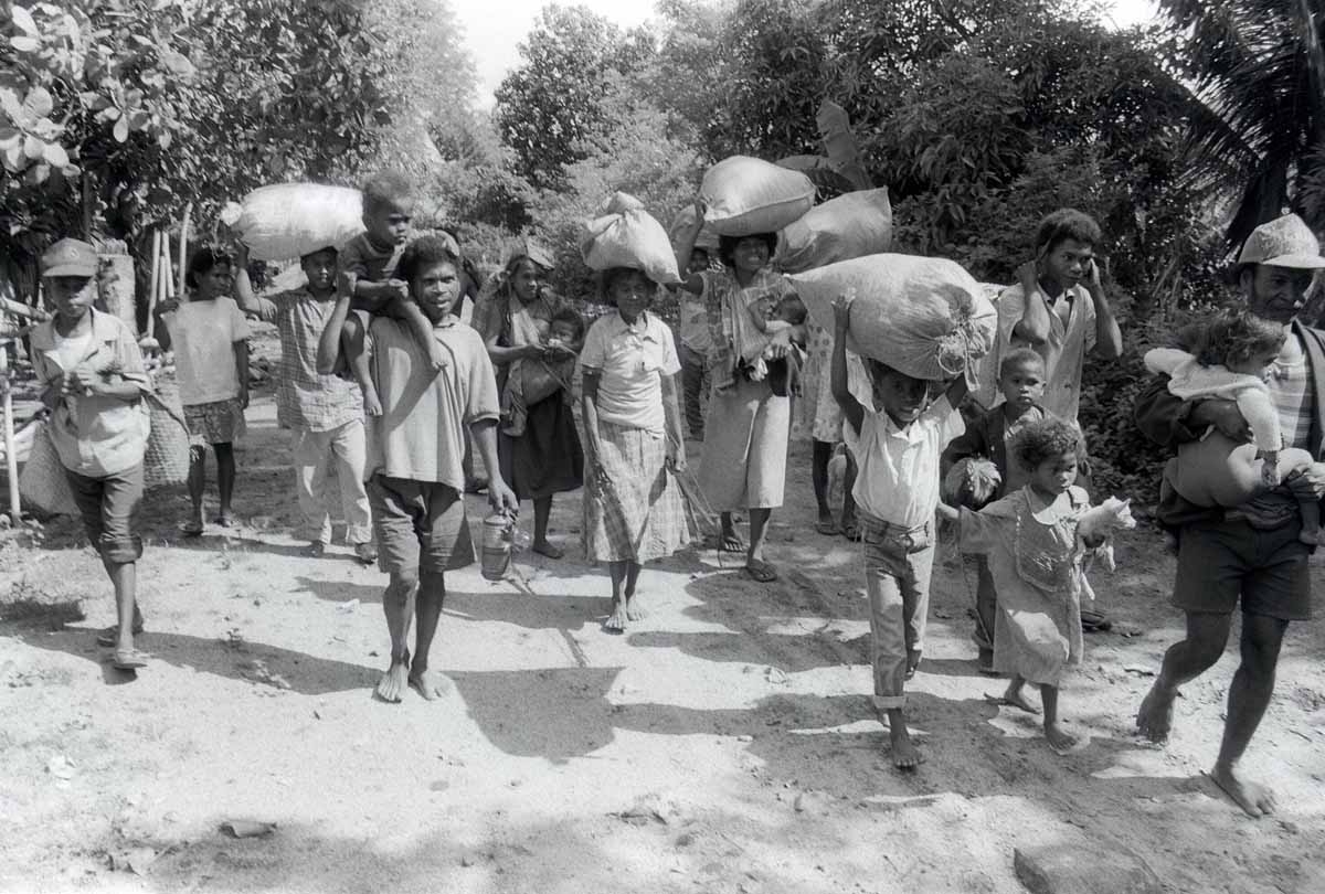 Aeta tribes-people flee their village with their meager belongings, 11 June 1991, in Botolan, which is within the 20-kilometer (12.4 miles) danger zone radius from the erupting Mount Pinatubo volcano. 