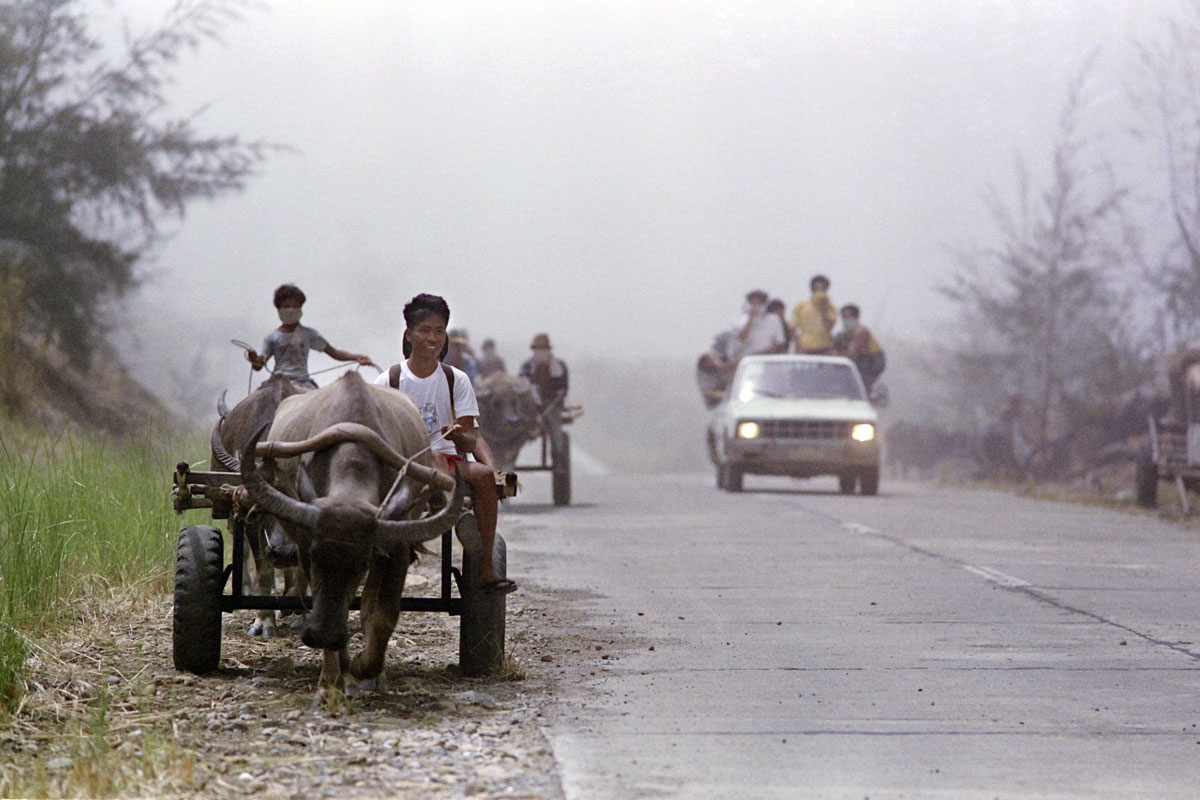 Farmers flee from Poon Bato on water buffalo drawn carts and on a jeep under a blanket of volcanic ash, on June 12, 1991 after the Mount Pinatubo eruption.