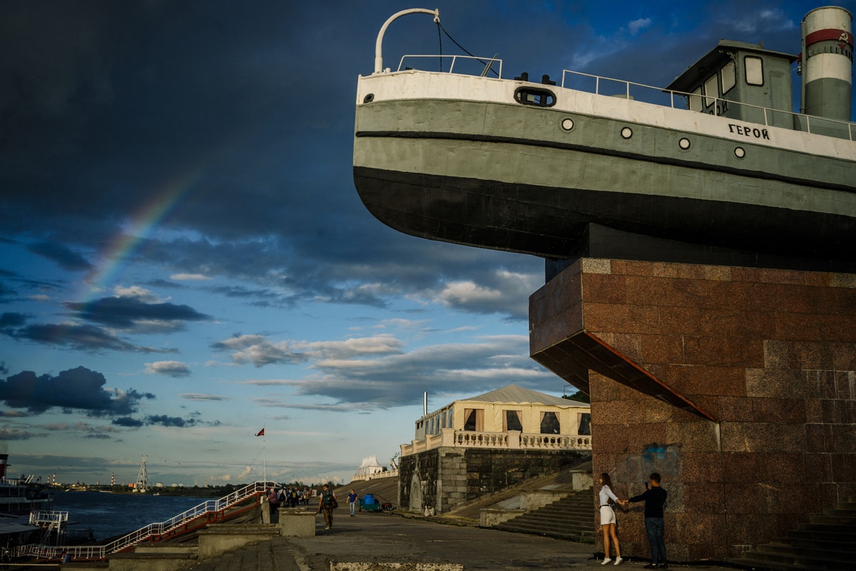 man takes a photo of his girlfriend on the bank of the Volga river in the city of Nizhny Novgorod on July 5, 2018.
