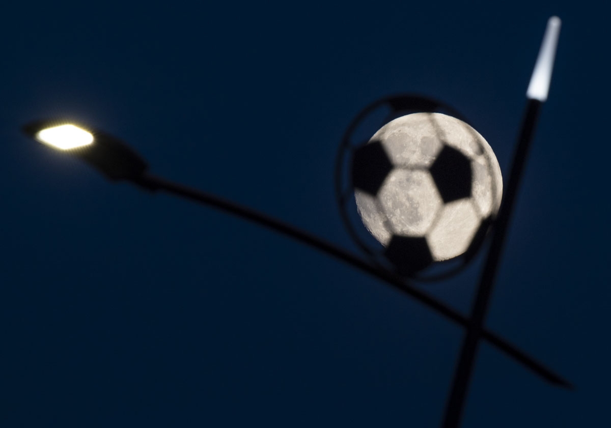 The moon shines behind a lamp post shaped as a soccer ball next to the Nizhny Novgorod Stadium in Nizhny Novgorod, on June 26, 2018 during the Russia 2018 World Cup tournament.