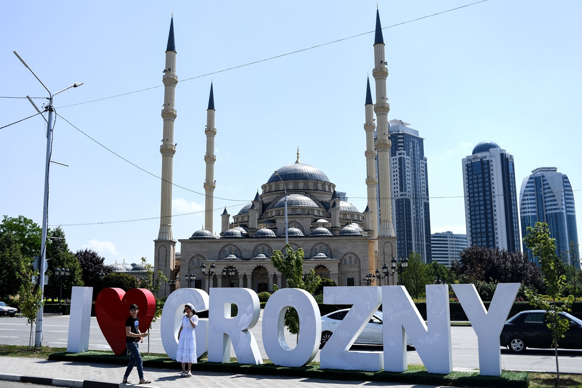 Young people take a photo in front of the Heart of Chechnya - Akhmad Kadyrov Mosque and large letters reading 'I love Grozny' in central Grozny on July 26, 2017. /