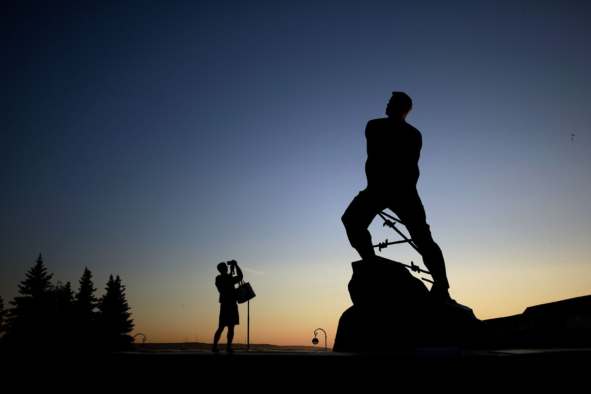 A man takes a picture of a statue at the entrance of the Kazan Kremlin in Kazan on June 16, 2018, during the Russia 2018 World Cup football tournament. / AFP PHOTO / Benjamin CREMEL