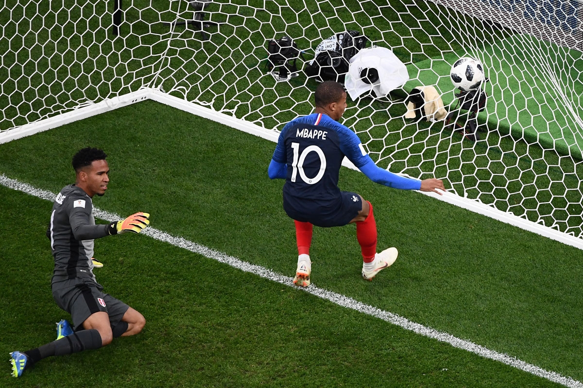 ance's forward Kylian Mbappe (R) scores a goal during the Russia 2018 World Cup Group C football match between France and Peru at the Ekaterinburg Arena in Ekaterinburg on June 21, 2018. / A