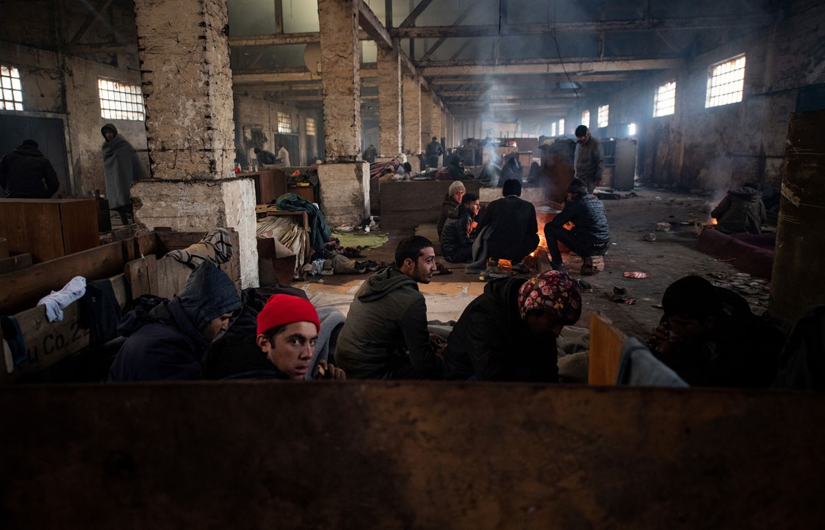 Migrants rest in a makeshift shelter in an abandoned warehouse in Belgrade on November 16, 2016.
