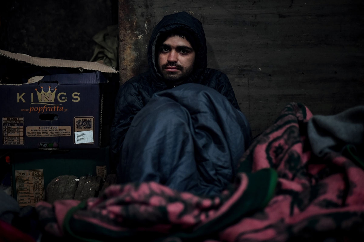 Mohamed Darwich,a 17-year old migrant from Afghanistan, poses in a makeshift shelter at an abandoned warehouse in Belgrade on December 8, 2016.