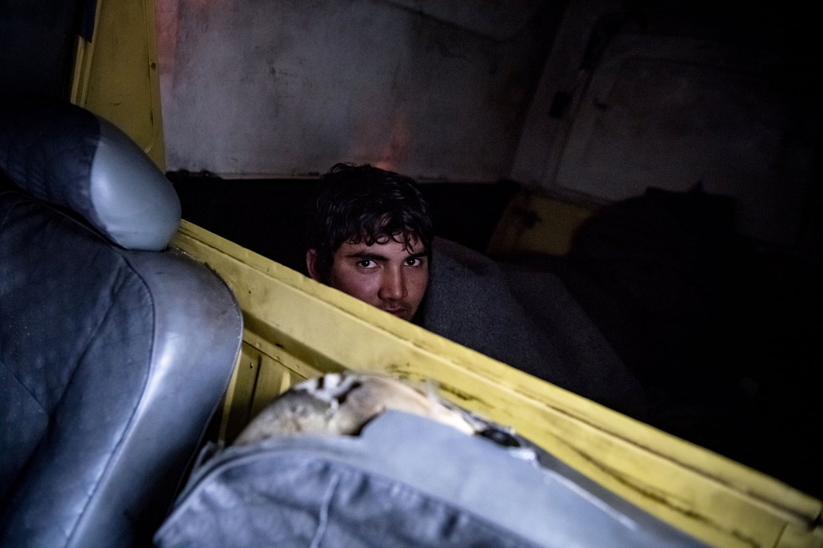 A migrant is pictured in an abandoned car he uses as a makeshift shelter near Belgrade's main railway station on January 17, 2017