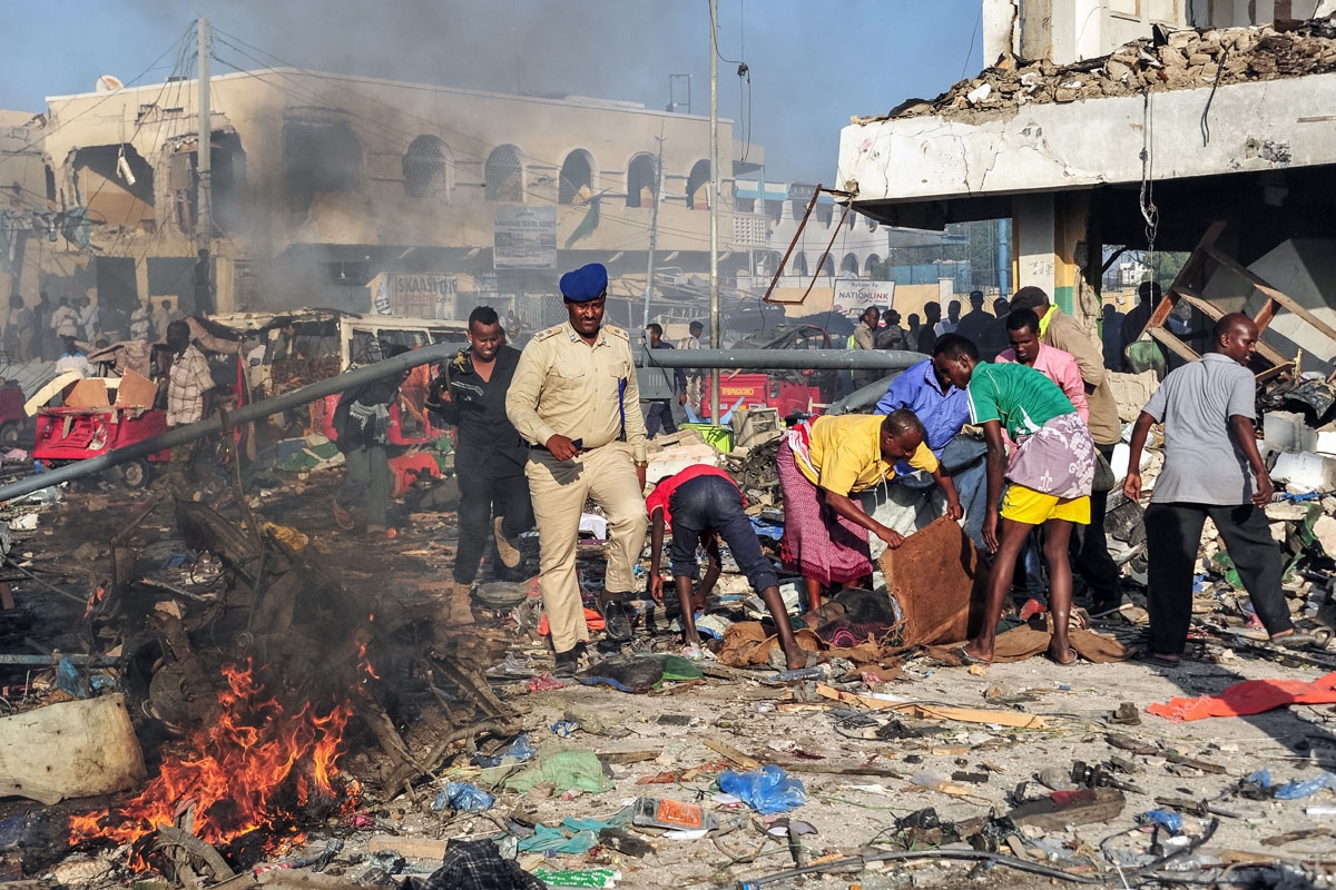 Men rescue victims on the site of the explosion of a truck bomb in the centre of Mogadishu, on October 14, 2017.