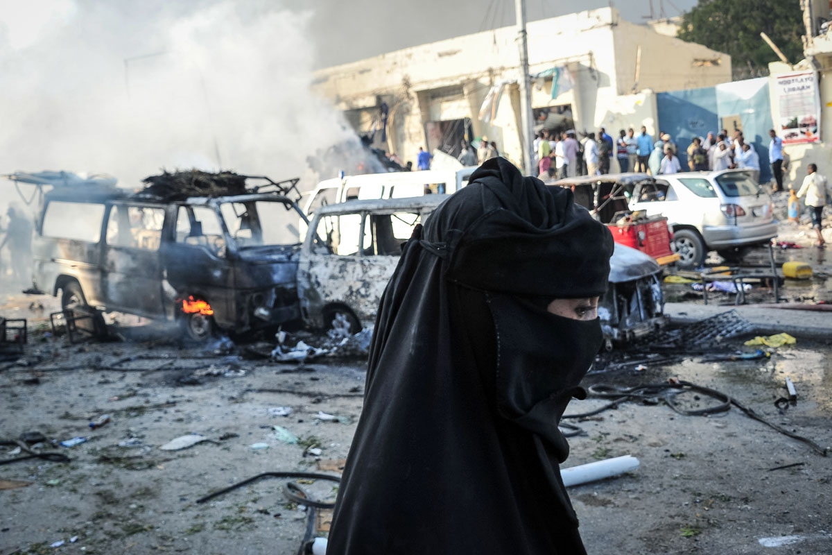 A woman walks by wreckages of vehicles following the explosion of a truck bomb in the centre of Mogadishu, on October 14, 2017.