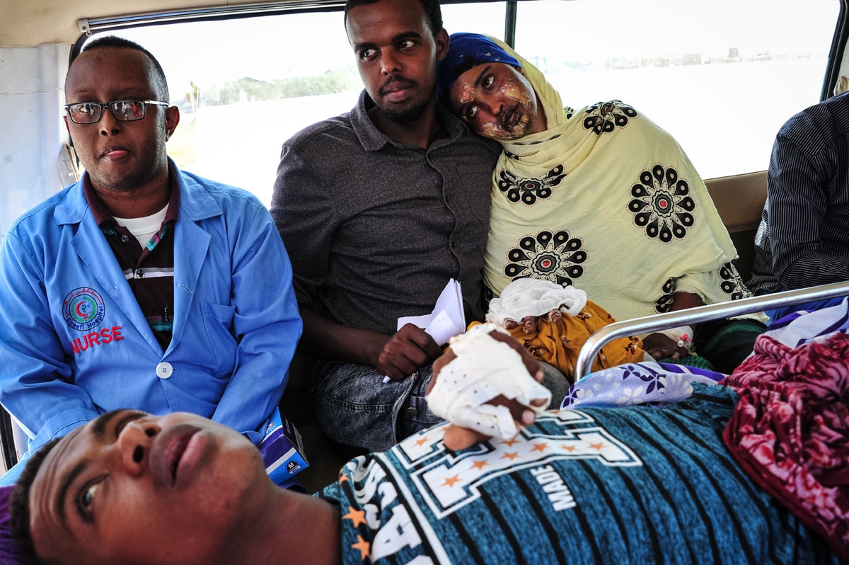 A Somali woman severely wounded by a truck bomb explosion three days prior leans on her husband before being transferred to an aircraft from an amburance at Aden Adde international airport in Mogadishu on October 17, 2017.