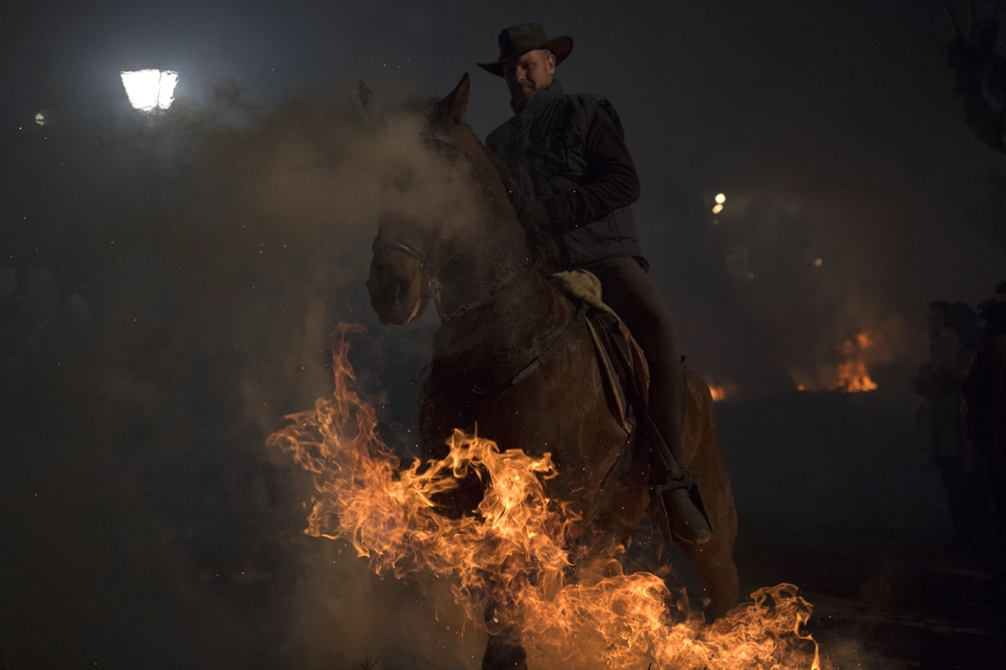 A horseman jumps over a bonfire in the village of San Bartolome de Pinares in the province of Avila in central Spain, during the opening of the traditional religious festival Luminarias in honour of San Antonio Abad (Saint Anthony), patron saint of animal
