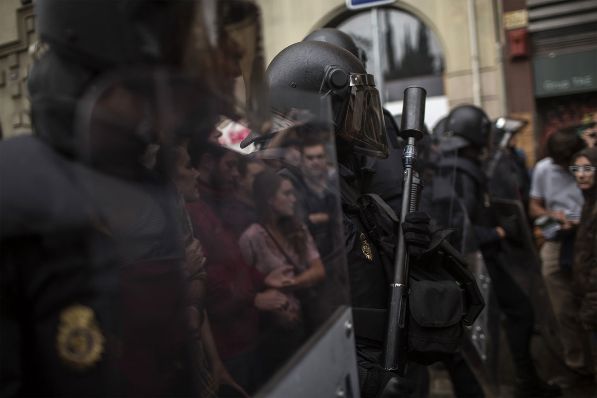 Protesters are reflected on the shields of Spanish police officers outside the Ramon Llull polling station in Barcelona October 1, 2017 during a referendum on independence for Catalonia banned by Madrid.