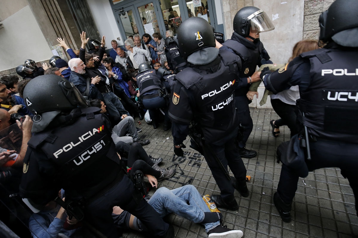 Spanish police officers try to disperse voters arriving to a polling station in Barcelona, on October 1, 2017 during a referendum on independence for Catalonia banned by Madrid. /