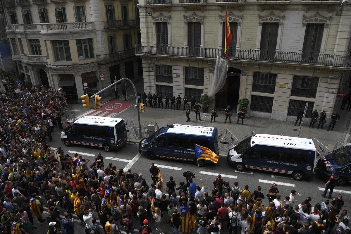 Protesters wave a Catalan pro-independence 'Estelada' flag as they gather outside the Spanish police headquarters in Barcelona as part of a general strike in Catalonia called by Catalan unions on October 3, 2017.