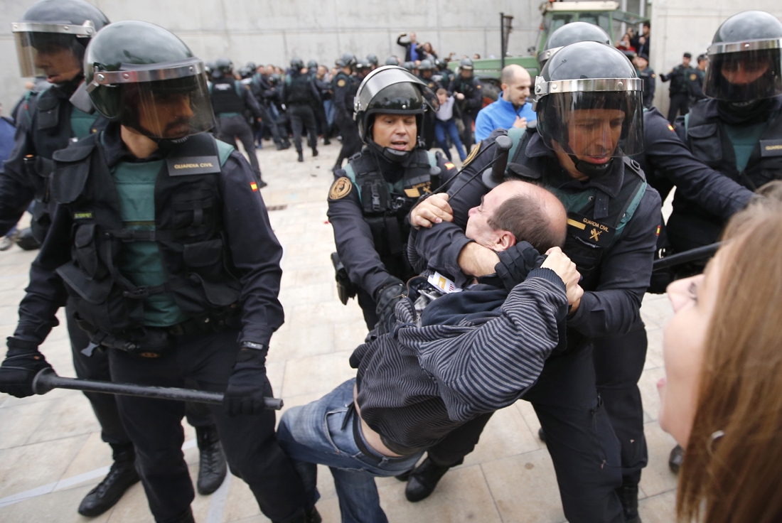 Spanish Guardia Civil guards drag a man outside a polling station in Sant Julia de Ramis, where Catalan president was supposed to vote, on October 1, 2017, on the day of a referendum on independence for Catalonia banned by Madrid.