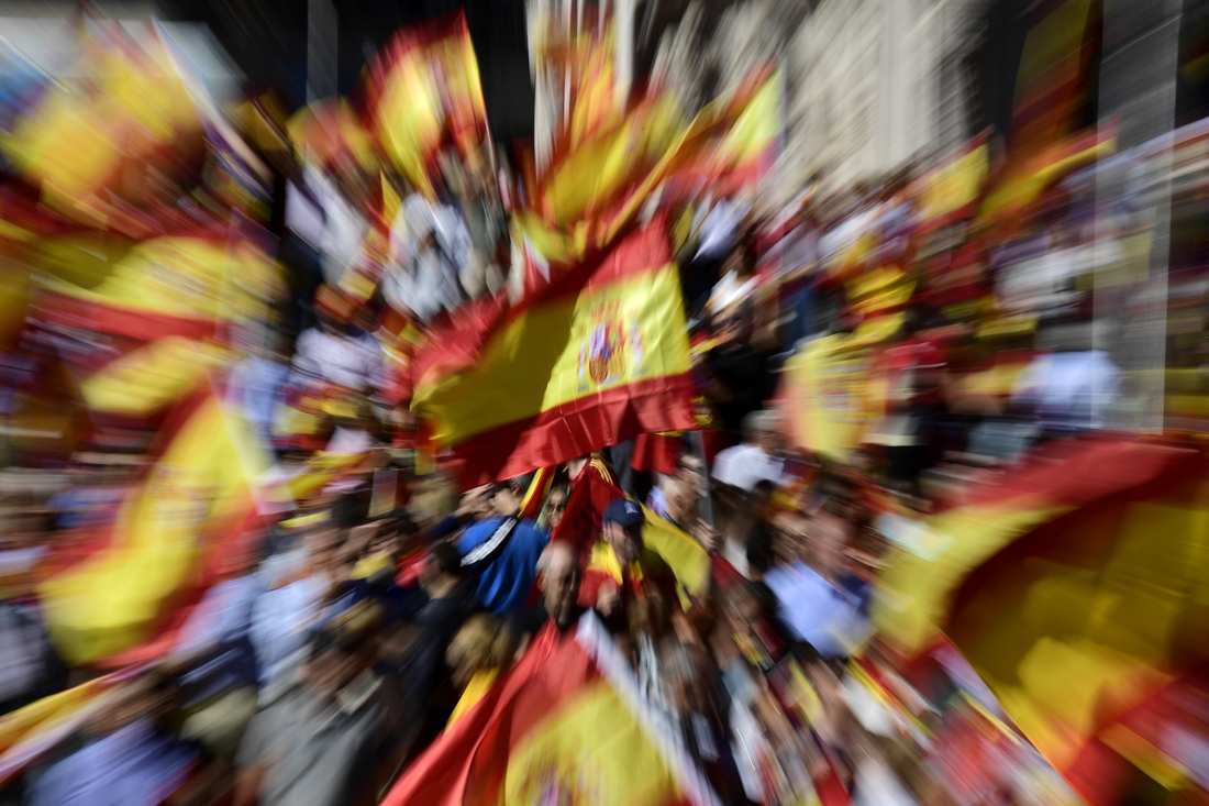 Protestors gather holding Spanish flags during a demonstration against independence of Catalonia called by DENAES foundation for the Spanish Nation Defence at Colon square in Madrid on October 07, 2017.