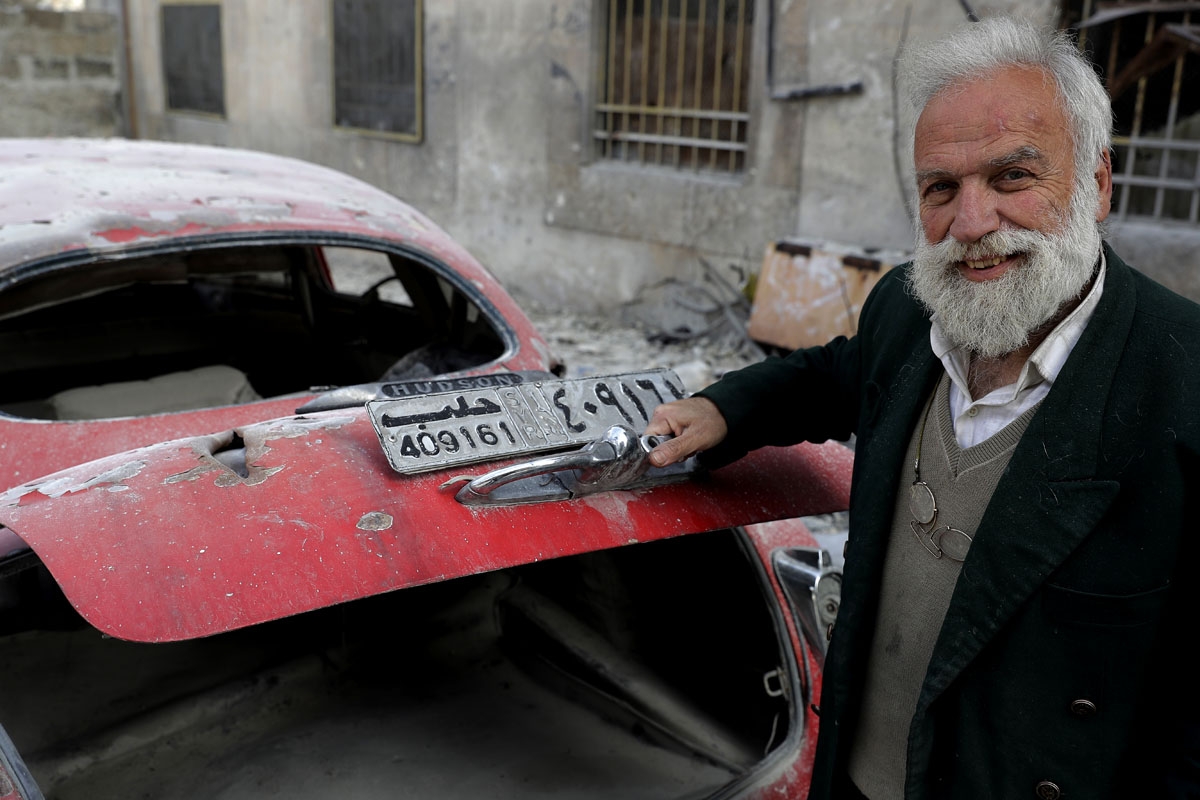 A picture taken on March 9, 2017, shows 70-year-old opening the trunk of his 1949 Hudson Commodor outside his home in Aleppo's formerly rebel-held al-Shaar neighbourhood.