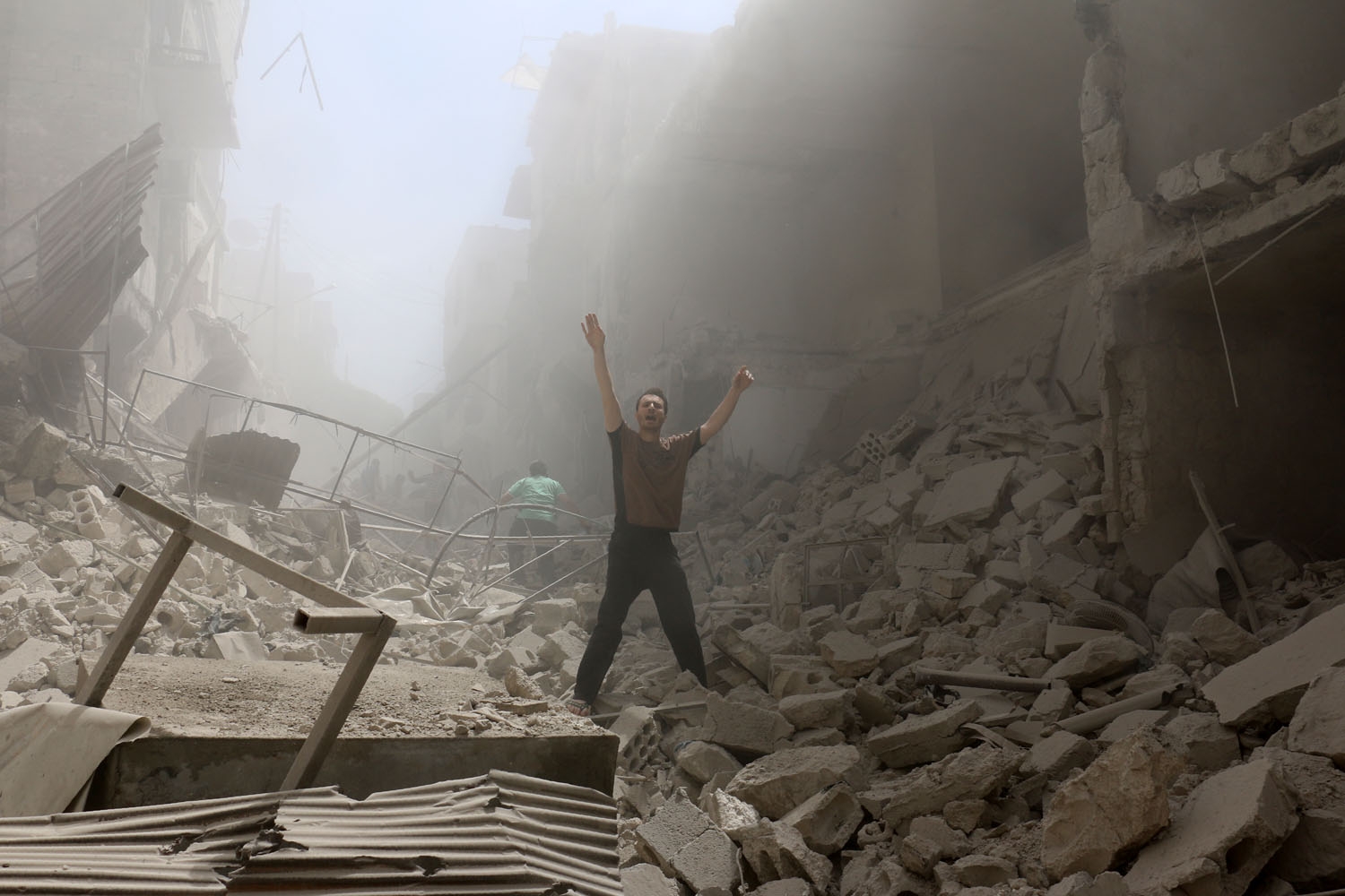 A man gestures amid the rubble of destroyed buildings following a reported air strike on the rebel-held neighbourhood of al-Kalasa in the northern Syrian city of Aleppo, on April 28, 2016