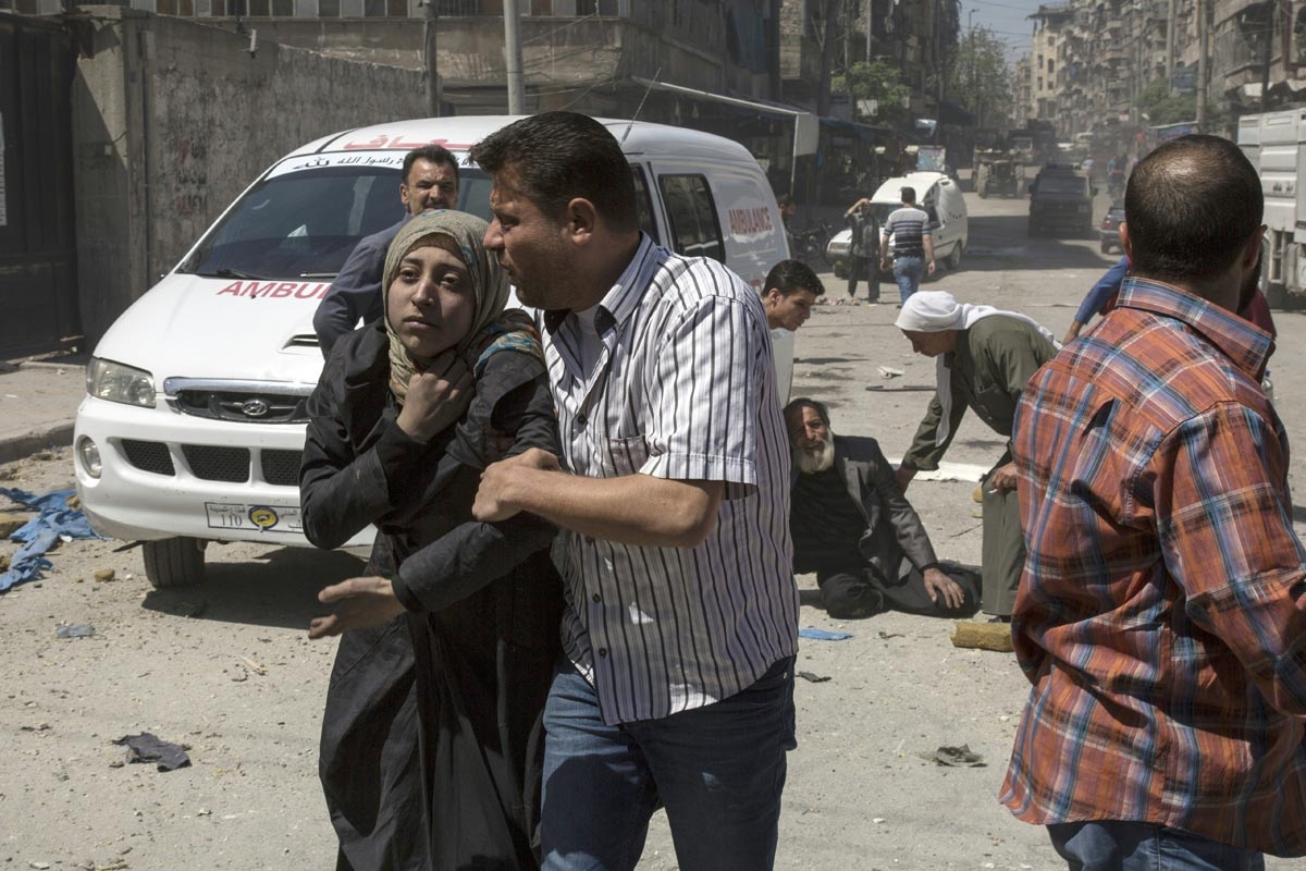 People in a state of shock receive help on a street following a reported airstrike on April 23, 2016 in the rebel-held neighbourhood of Tareeq al-Bab in the northern city of Aleppo