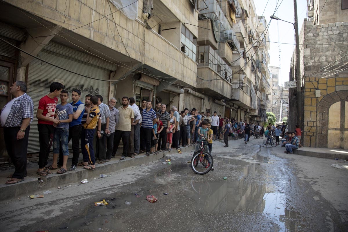 Syrians queue up to buy bread in a rebel held neighbourhood in the northern city of Aleppo on July 12, 2016.